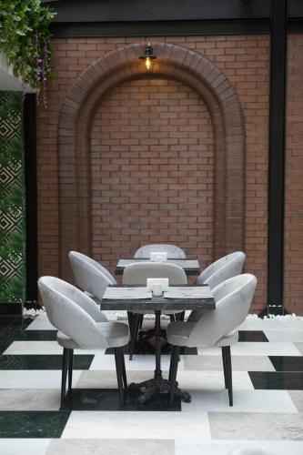 a table and chairs in front of a brick wall at Emens hotel in Izmir