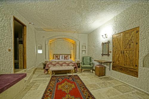 a bedroom with a bed and a chair and a rug at Risus Cave Suites in Goreme