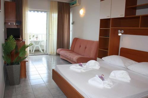um quarto de hotel com uma cama e um sofá em Apartments Ivan em Omiš
