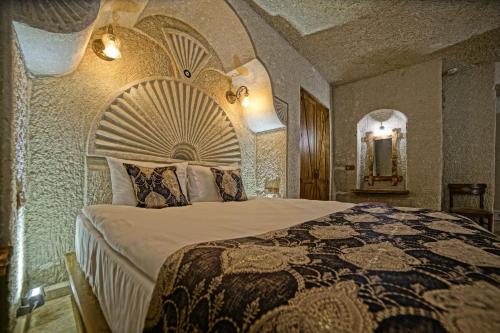 a bedroom with a large bed with a large bedspread at Risus Cave Suites in Goreme