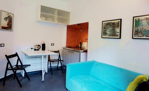 a living room with a blue couch and a kitchen at Studio Apartment Vicolo Lavandai in Milan
