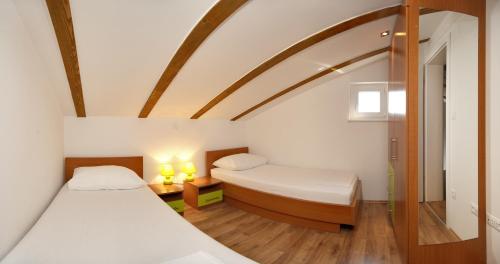due letti in una piccola stanza con soffitto a volta di Apartmani Gavran a Sevid