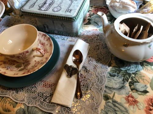 una mesa con una taza de té y una cuchara en L'Ape Regina, en Ferrara
