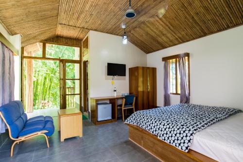 a bedroom with a bed and a desk and chairs at Balishira Resort Ltd. in Sreemangal