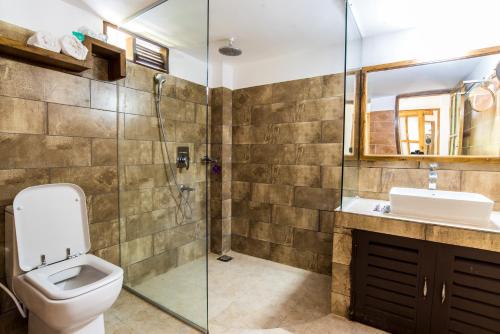 y baño con aseo, lavabo y ducha. en Balishira Resort Ltd., en Sreemangal