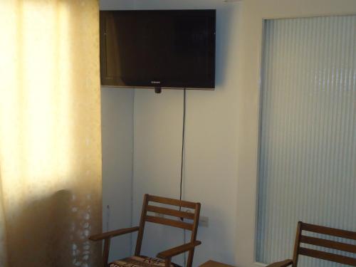 a room with two chairs and a television on a wall at Original house in Larisa