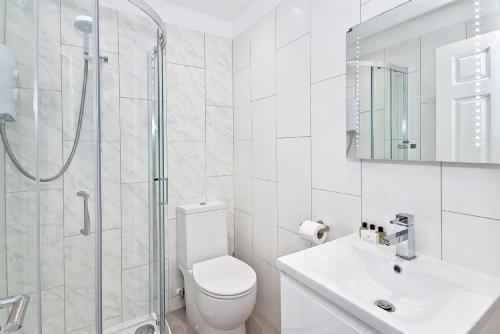 a bathroom with a toilet and a shower and a sink at F5 Greek Street by City Living London in London