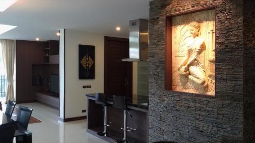a kitchen with a wall with a painting on it at Karon Suite Apartment in Karon Beach