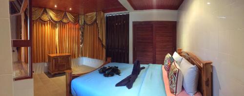 a bedroom with a bed with a blue comforter at Krabi Villa Phu Khao Private Resort in Klong Muang Beach