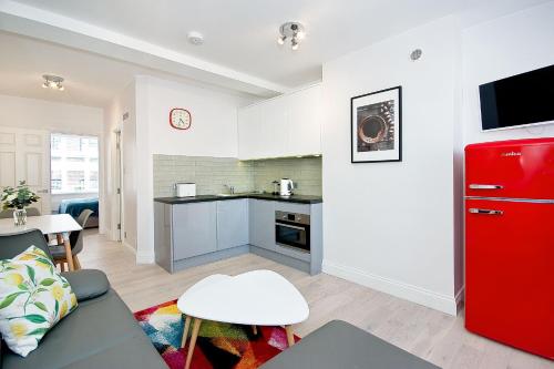 a living room with a couch and a red refrigerator at F4 Greek Street by City Living London in London