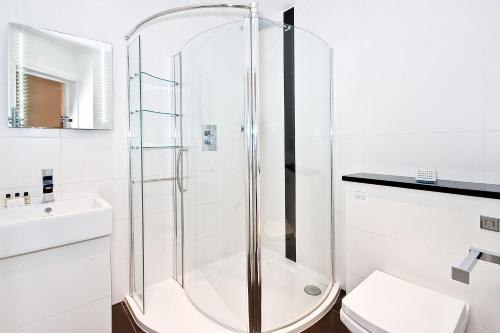 Apartment 1, 48 Bishopsgate by City Living London في لندن: دش في حمام مع مرحاض ومغسلة