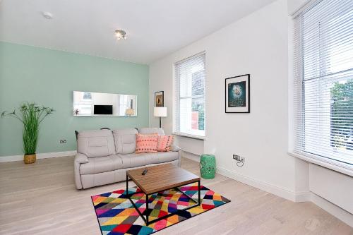 a living room with a couch and a coffee table at Interlude House B by City Living London in London