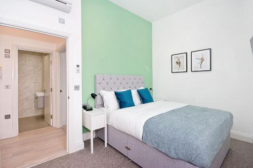 a bedroom with a bed and a walk in shower at Interlude House B by City Living London in London