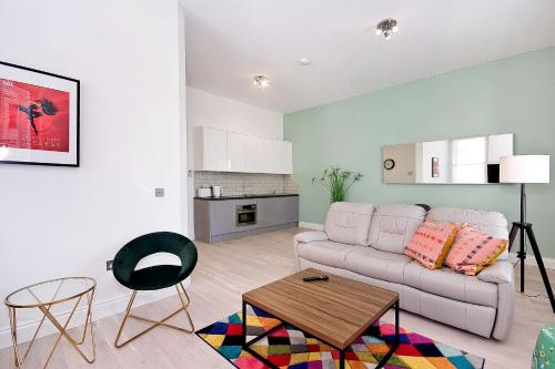 a living room with a white couch and a table at Interlude House B by City Living London in London