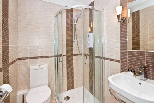 a bathroom with a shower and a toilet and a sink at F2 Greek Street by City Living London in London
