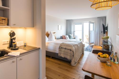 a kitchen and a bedroom with a bed in a room at Ostsee-Strandhaus-Holnis in Glücksburg