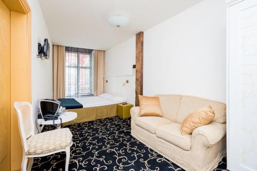 a living room with a couch and a bed at Meriton Old Town Garden Hotel in Tallinn