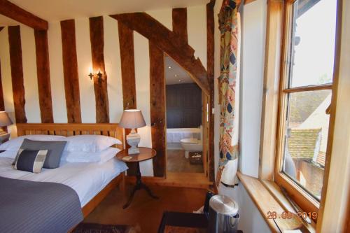sypialnia z łóżkiem oraz łazienka z wanną w obiekcie White Hall Farm w mieście Leamington Spa