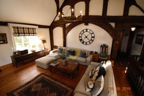 an overhead view of a living room with a clock on the wall at White Hall Farm in Leamington Spa