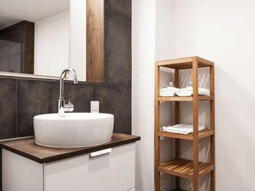 ein Badezimmer mit einem Waschbecken und einem Regal mit Handtüchern in der Unterkunft Gästewohnung Jakobsgasse in Tübingen