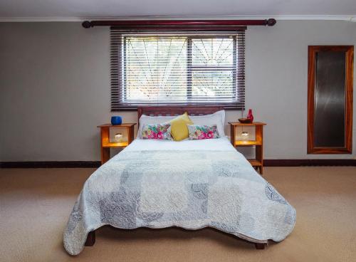 una camera con un grande letto e una finestra di Staymore Guesthouse a Stellenbosch