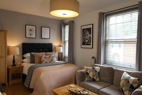 a bedroom with a bed and a couch at The Larches in Wolverhampton