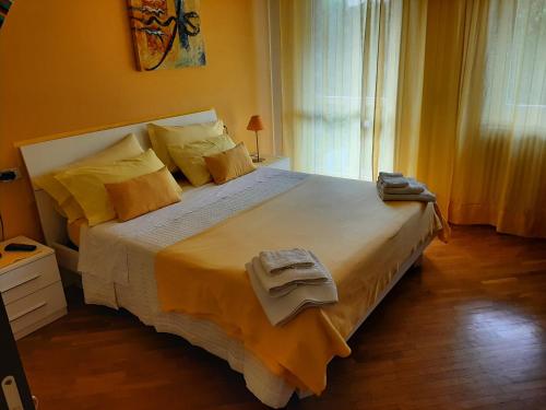 a bedroom with a large bed with yellow walls at The Village B&B in Bergamo