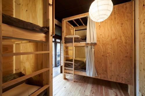 a room with bunk beds in a log cabin at ちゃぶだい Guesthouse,Cafe&Bar in Kawagoe