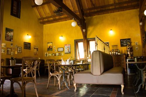 a restaurant with yellow walls and a table and chairs at Hotel Bougainviller in Kampala