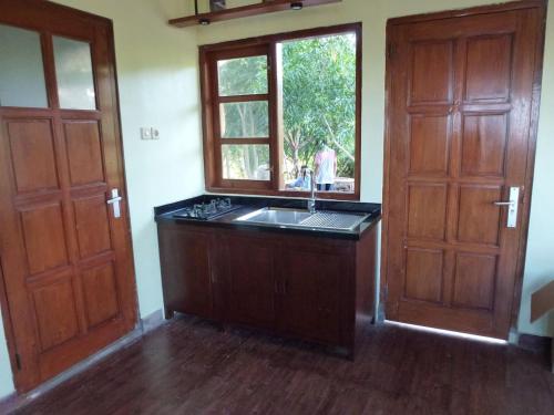 eine leere Küche mit Spüle und Fenster in der Unterkunft Fam Sugiono Cottage - Studio House in Kemadang