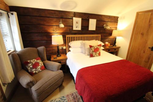a hotel room with a bed, chair, and table at Boutique Garden Lodge @ The Larches in Wolverhampton