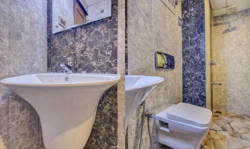 a bathroom with a sink and a toilet at Hotel Garden Inn in Cochin