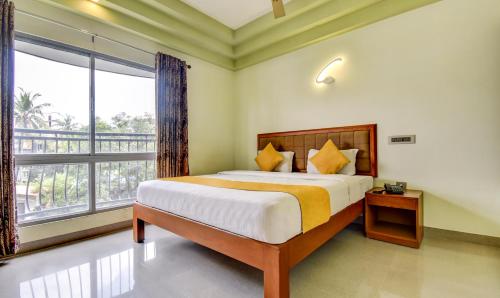a bedroom with a large bed and a large window at Hotel Garden Inn in Cochin
