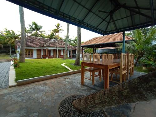 a patio with a table and chairs and a house at Breeze Backwater Homes in Cochin