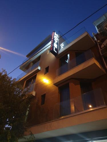 a building with a neon sign on the side of it at Family Hotel Novel City in Burgas
