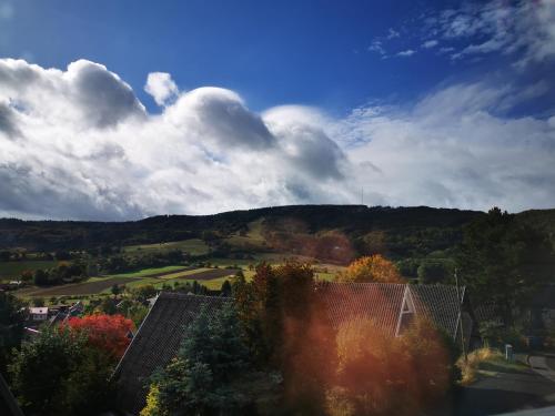 a view of a house with a hill in the background at Ferienhaus in der Rhön Sitzmann in Bischofsheim an der Rhön