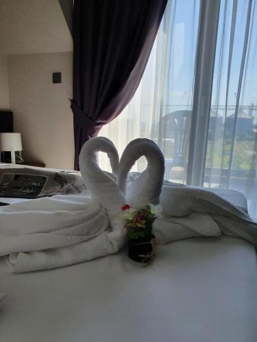 two swans made out of towels on a bed at Family Hotel Novel City in Burgas