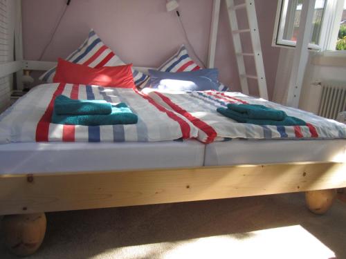 a bed with red white and blue blankets and pillows at Apartment am Birnbaum in Reutlingen