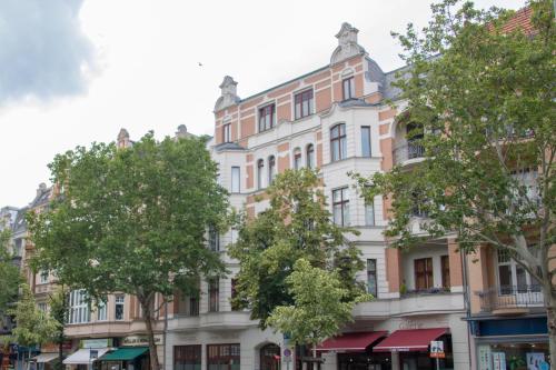 a building on a street with trees in front at Madflats Hotel-Apartments S-Bahn Friedenau in Berlin