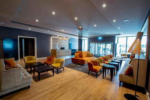 a living room with couches and tables and chairs at Caravelle Hotel im Park in Bad Kreuznach