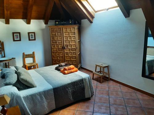 a bedroom with a bed and a chair and a window at CASA GRACIANO I in Ochagavía