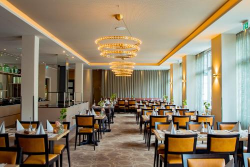 a dining room filled with tables and chairs at Caravelle Hotel im Park in Bad Kreuznach