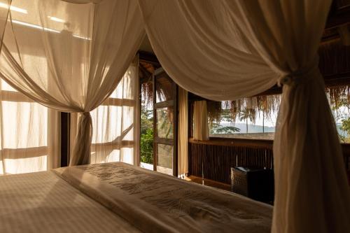 a bedroom with a bed with a canopy and a window at Lodges Boutique La Nuit in La Vega