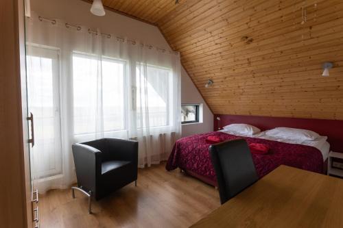 um quarto com uma cama, 2 cadeiras e uma mesa em Guesthouse Dalbaer em Fludir