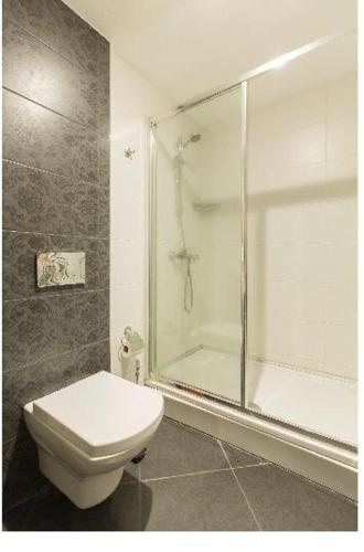 a bathroom with a toilet and a glass shower at CTS Elysium Residence Taksim in Istanbul