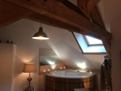 ein Bad mit Badewanne in der Mitte eines Zimmers in der Unterkunft Le Grand Gîte in Dorengt