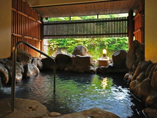 a pool of water in a room with rocks at Yamabiko Ryokan in Minamioguni