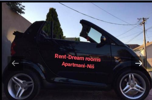 a black car with a sign on the side of it at Apartments & Dream Rooms in Niš