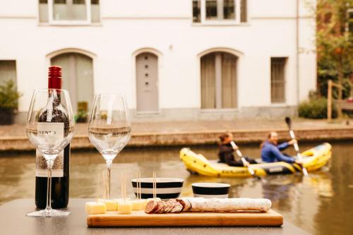 a bottle of wine and a glass and some people on a raft at UKI-Hotel in Utrecht