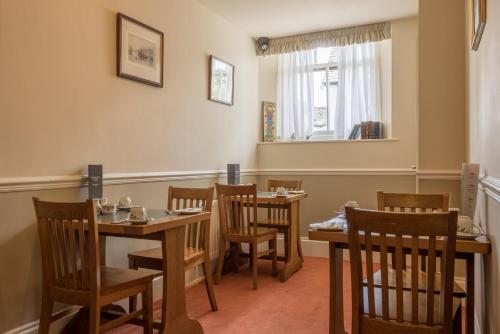 a dining room with wooden tables and chairs at Windermere Park B&B inc Free off-site Health Club in Windermere